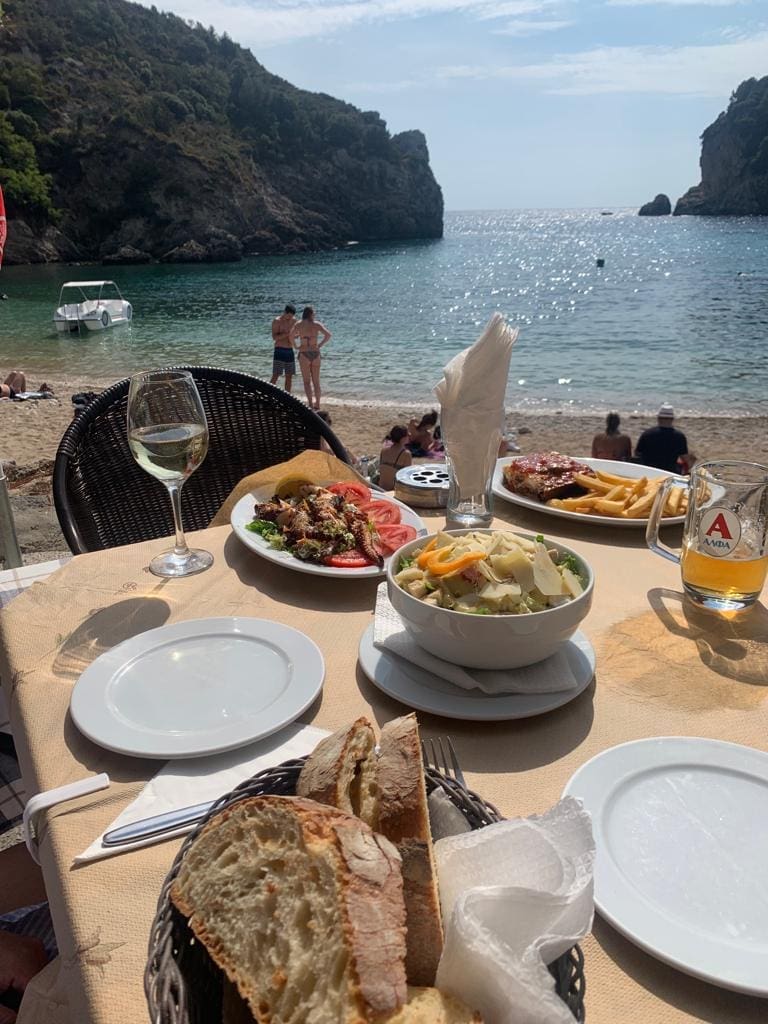 Lunch bij de taverne op het strand van Paleokastritsa op het eiland Corfu.