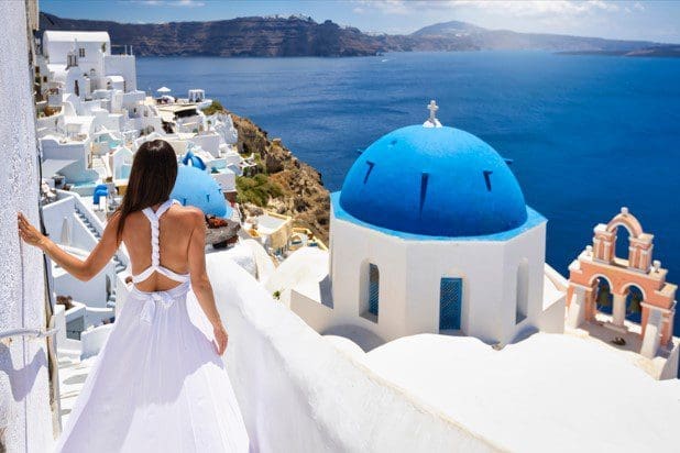 Fantastische blauwe koepel met roze bel op Santorini